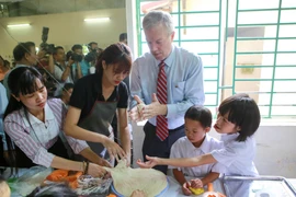 Đại sứ Mỹ hào hứng làm bánh nướng, bánh dẻo cùng các em nhỏ nạn nhân chất độc da cam dioxin. (Ảnh: Minh Sơn/Vietnam+)
