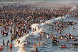 Những ngày nắng nóng đỉnh điểm vừa qua, lượng khách đổ về khu du lịch Sầm Sơn tăng cao đột biến. (Ảnh: PV/Vietnam+)