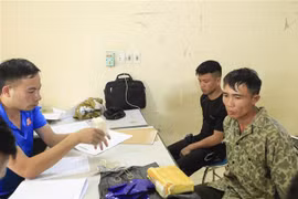 Hai đối tượng cùng tang vật tại cơ quan điều tra. (Ảnh: Xuân Tư/TTXVN)