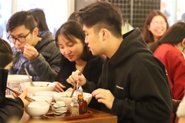 Các bạn trẻ du học sinh Việt Nam tại Melbourne thích thú thưởng thức Phở Thìn 13 Lò Đúc. (Ảnh: Diệu Linh/Vietnam+)