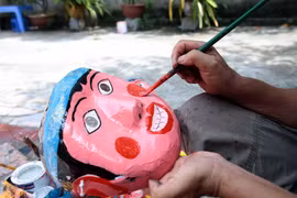 Mặt nạ được những nghệ nhân tỉ mẩn vẽ mô phỏng lại các nhân vật dân gian. (Ảnh: Phạm Kiên/TTXVN)