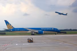 Máy bay của hãng hàng không Vietnam Airlines cất và hạ cánh tại sân bay Tân Sơn Nhất. (Ảnh: Ngọc Hà/TTXVN)