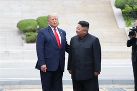 Tổng thống Mỹ Donald Trump (trái) và nhà lãnh đạo Triều Tiên Kim Jong-un trong cuộc gặp ở làng đình chiến Panmunjom tại Khu phi quân sự (DMZ) chiều 30/6/2019. (Ảnh: Yonhap/TTXVN)