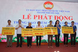 Đại diện Ủy ban Mặt trận Tổ quốc Việt Nam thành phố Hà Nội trao kinh phí hỗ trợ xây 5 nhà "Đại đoàn kết" cho các hộ nghèo. (Ảnh: Nguyễn Thắng/TTXVN)