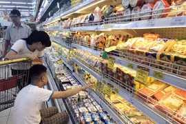 Khách hàng lựa chọn hàng hóa tại siêu thị. (Ảnh: Trần Việt/TTXVN)