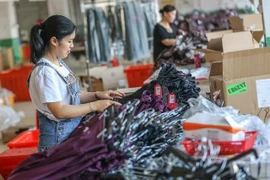Công nhân làm việc trong một nhà máy dệt may ở tỉnh Phúc Kiến của Trung Quốc. (Ảnh: AFP/TTXVN)
