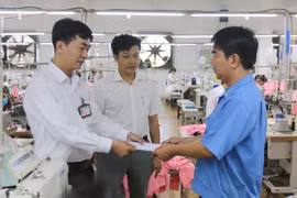 Ông Lê Văn Hải, Phó Tổng Giám đốc Công ty Cổ phần Thương mại xuất nhập khẩu May Phương Nam, quận Gò Vấp (giữa) cùng Chủ tịch Công đoàn Công ty Trần Phú Vinh (trái) tặng quà Tết Dương lịch 2020 cho công nhân lao động có hoàn cảnh khó khăn. (Ảnh: Thanh Vũ/T
