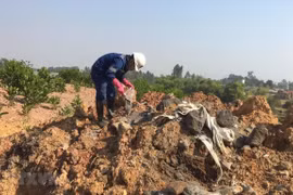 Viện Khoa học và Công nghệ Môi trường lấy mẫu để phân tích thành phần có trong chất thải bị đổ trộm tại thôn Lai Thôn, xã Bắc Sơn, huyện Sóc Sơn, Hà Nội. (Ảnh: Mạnh Khánh/TTXVN)