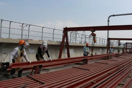 Công nhân thi công đường ray tuyến metro số 1 tại ga Phước Long. (Ảnh: Tiến Lực/TTXVN)