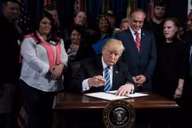 Tổng thống Mỹ Donald Trump (giữa) ký một sắc lệnh ở Washington, DC ngày 27/4. (Nguồn: AFP/TTXVN)