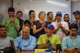 Thủ lĩnh phe đối Venezuela Henrique Capriles (áo xanh đội mũ) phát biểu tại buổi họp báo ở thủ đô Caracas. (Nguồn: EPA/TTXVN) 