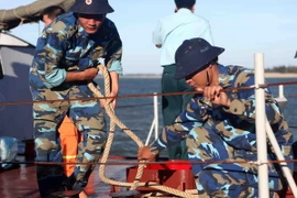 Chiến sỹ tàu HQ221 tháo dây neo tàu lên đường đi cứu nạn. (Ảnh: Thanh Tùng/TTXVN)