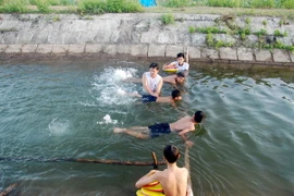 Hướng dẫn các em kỹ năng bơi lội. (Ảnh: Thanh Thủy/TTXVN)