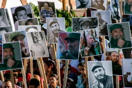 Người dân mang theo di ảnh của cố Lãnh tụ Fidel Castro tham gia lễ tuần hành tại Santiago de Cuba ngày 4/12. (Ảnh: THX/TTXVN)