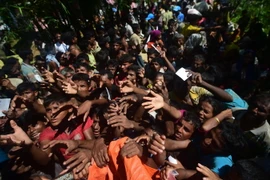 Người tị nạn Rohingya nhận hàng cứu trợ tại Palongkhali, gần Ukhia sau khi vượt qua sông Naf ở Myanmar để tới Bangladesh ngày 16/10 vừa qua. (Ảnh: AFP/TTXVN)