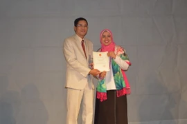 Đại sứ Việt Nam tại Ai Cập Đỗ Hoàng Long trao giấy khen cho nghệ sỹ Nhà hát múa rối Cairo May Mohab. (Ảnh: Nguyễn Tùng/VietnamPlus)