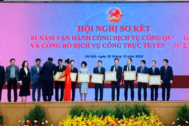 Lãnh đạo NAPAS nhận bằng khen của Văn phòng Chính phủ ghi nhận nỗ lực của NAPAS trong việc kết nối, cung cấp dịch vụ thanh toán trên cổng Dịch vụ công quốc gia trong năm 2020. (Ảnh: CTV/Vietnam+)