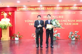 Ông Y Thanh Hà Niê Kđăm-Bí thư Đảng ủy Khối Doanh nghiệp Trung ương (bên trái) trao Kỷ niệm chương "Vì sự nghiệp kiểm tra của Đảng" của Ủy ban Kiểm tra Trung ương cho ông Nghiêm Xuân Thành- Bí thư Đảng ủy, Chủ tịch HĐQT Vietcombank. (Ảnh: Vietnam+)
