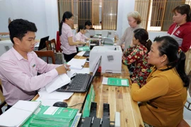 Khách hàng giao dịch tại Ngân hàng Chính sách xã hội. (Ảnh: Vietnam+)