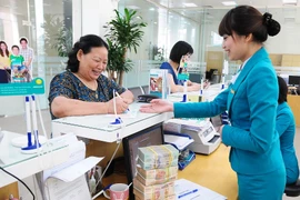 Giao dịch tại ngân hàng. (Ảnh: CTV/Vietnam+)