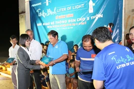 Bà Nguyễn Thị Hương, Phó Tổng giám đốc ABBANK trao quà cho người dân Bình Phước. (Ảnh: CTV/Vietnam+)