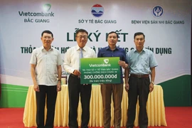Lãnh đạo Vietcombank trao tiền ủng hộ cho Sở Y tế Bắc Giang để phục vụ cho công tác phòng, chống dịch COVID-19. (Ảnh: Vietnam+)