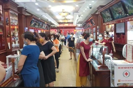 Nhiều người dân xếp hàng mua bán vàng tại Bảo Tín Minh Châu trên phố Trần Nhân Tông, Hà Nội chiều ngày 6/8. (Ảnh: PV/Vietnam+)