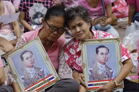 Nhiều người dân ngồi hàng giờ dưới cái nóng để chờ được nhìn thấy đoàn xe tang của nhà vua đi qua. (Nguồn: Dailymail)