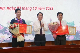 Phó Chủ tịch UBND thành phố Hải Phòng Lê Khắc Nam khen thưởng vận động viên Phạm Quang Huy và huấn luyện viên. (Ảnh: Hoàng Ngọc/TTXVN)