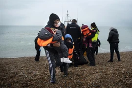 Người di cư được đưa về bãi biển ở Dungeness, phía Đông Nam vùng England, sau khi được giải cứu ở eo biển Channel. (Ảnh: AFP/TTXVN)