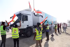 Xe tải chở hàng viện trợ di chuyển từ Ai Cập qua cửa khẩu Rafah vào Dải Gaza. (Ảnh: THX/TTXVN)