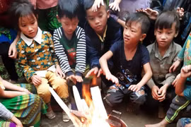 Các em học sinh trường vùng núi sưởi ấm trước khi vào lớp học. (Ảnh: Đinh Thùy/TTXVN)