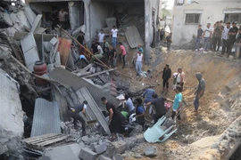 Người dân tìm kiếm người bị mắc kẹt trong những đống đổ nát sau vụ không kích của Israel tại Khan Younis, Dải Gaza. (Ảnh: THX/TTXVN)
