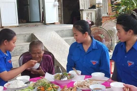 Các bạn đoàn viên thanh niên chăm sóc Mẹ Việt Nam Anh hùng Cao Thị Chánh (99 tuổi) ở thôn Hiền Lương, xã Nghĩa Hà, thành phố Quảng Ngãi. (Ảnh: Đinh Hương/TTXVN)