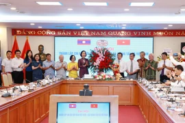 Bà Vũ Việt Trang, Tổng giám đốc Thông tấn xã Việt Nam, tặng hoa chúc mừng Ban Chấp hành Chi hội Hữu nghị Việt Nam-Lào Thông tấn xã Việt Nam. (Ảnh: Phương Hoa/TTXVN)