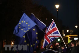 Quốc kỳ Anh (phải) và cờ EU bên ngoài Hạ viện Anh ở London ngày 12/12/2018. (Nguồn: THX/TTXVN)