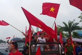 Trên dọc tuyến đường vào sân bay quốc tế Nội Bài, rất đông người hâm mộ đã đeo băng rôn và mang cờ hoa ra đón các cầu thủ Đội tuyển Olympic Việt Nam. (Nguồn: Quang Quyết/TTXVN)