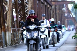 Người dân với trang phục áo ấm đi trên cầu Long Biên, Hà Nội. (Ảnh: Danh Lam/TTXVN)