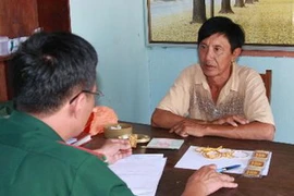 Đối tượng Hoàng Văn Han cùng tang vật tại cơ quan điều tra. (Ảnh: Hồ Cầu/TTXVN)