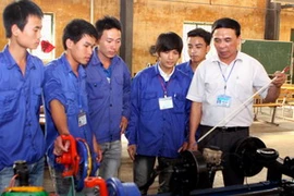 Hướng dẫn học viên thực hành nghề cơ khí. (Ảnh: Hà Thái/TTXVN)