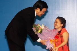 Chủ tịch nước Trương Tấn Sang tặng hoa cho đại biểu người khuyết tật Thành phố Hồ Chí Minh Nguyễn Thị Kim Chi. (Ảnh: Anh Tuấn/TTXVN)