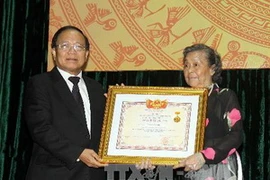 Bộ trưởng, Bộ Văn hóa, Thể thao và Du lịch trao danh hiệu nghệ sỹ ưu tú của cố nghệ sỹ Nguyễn Văn Hiệp cho đại diện gia đình nghệ sỹ. (Ảnh: Thanh Tùng/TTXVN)