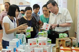 Khách thăm gian hàng giới thiệu các loại dược phẩm của Công ty dược phẩm Hà Tây tại triển lãm. (Ảnh: Quý Trung/TTXVN)