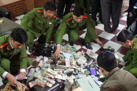 Cảnh sát kiểm tra tang vật thu được tại hiện trường. (Nguồn: Vnexpress)