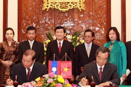 Chủ tịch nước Trương Tấn Sang chứng kiến lễ ký Bản ghi nhớ Hợp tác giữa hai văn phòng Chủ tịch nước Việt Nam và Lào. (Ảnh: Nguyễn Khang/TTXVN)