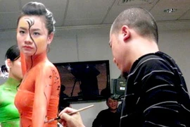 Phương Vũ Mạnh vẽ trên cơ thể người mẫu. (Ảnh: TT&VH)