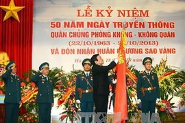 Chủ tịch nước Trương Tấn Sang gắn Huân chương Sao Vàng lên Cờ truyền thống của Quân chủng. (Ảnh: Trọng Đức/TTXVN)
