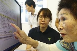Một cụ bà Hàn Quốc kiểm tra tên mình trong danh sách xin tham gia đoàn tụ các gia đình bị ly tán tại trụ sở Hội Chữ thập Đỏ ở Seoul ngày 20/8.(Nguồn: Yonhap/TTXVN)