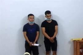 Các đối tượng có liên quan bị bắt giữ tại hiện trường. (Ảnh: TTXVN phát)