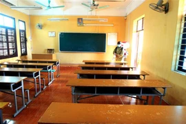 Phun thuốc khử khuẩn tại điểm thi trường THPT Thái Phiên. (Ảnh: An Đăng/TTXVN)